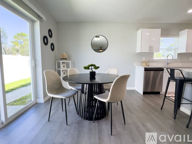 A modern dining room with a round table and chairs.