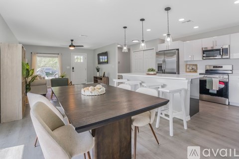 A modern kitchen with a dining table and chairs.