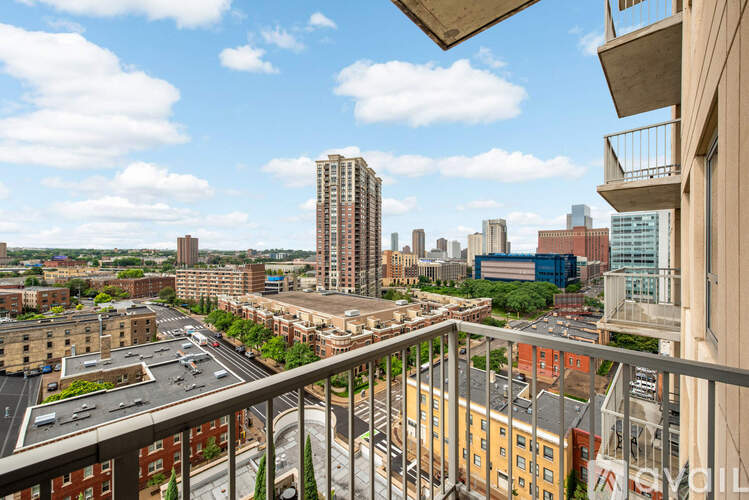 A cityscape viewed from a balcony with a mix of residential and commercial buildings.