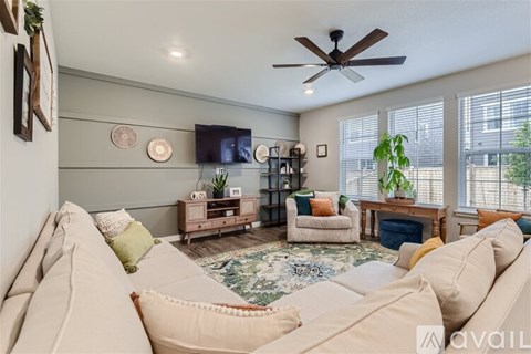 A living room with a white couch and a ceiling fan.
