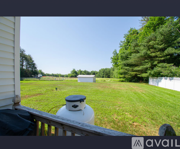 A white propane tank sits on a wooden deck.