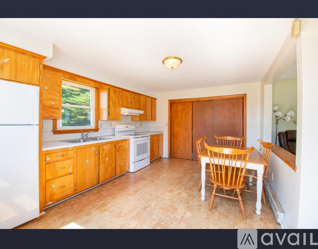 A kitchen with wooden cabinets and a dining table.