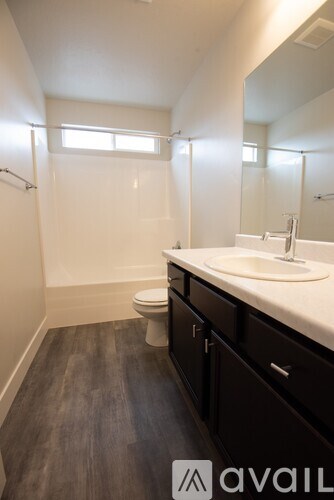 A bathroom with a toilet, sink, and mirror.