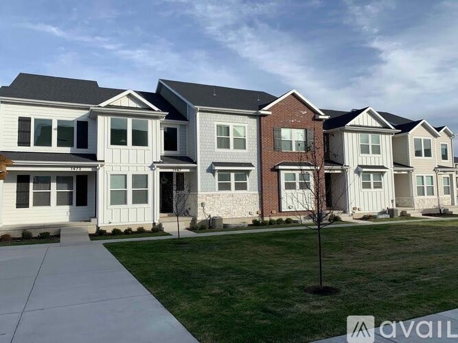 A row of houses with the first one having a white door and the second one having a brown door.