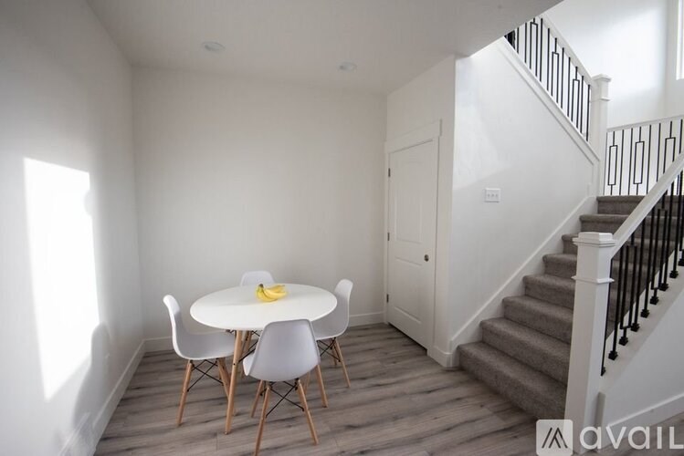 A dining room with a white table and chairs.