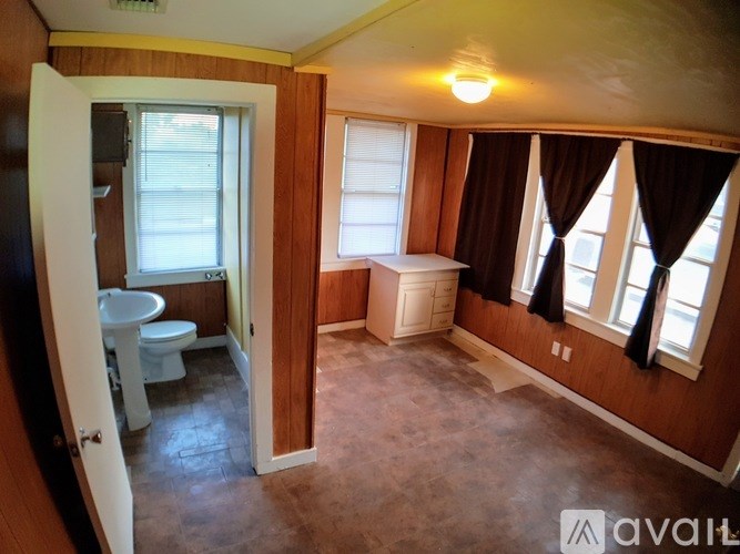 A bathroom with brown walls and a white toilet and sink.