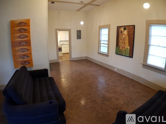 A living room with a couch and a painting on the wall.
