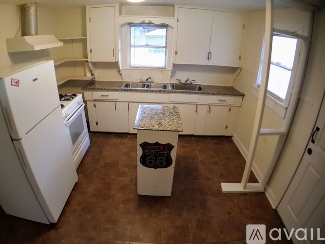 A kitchen with white appliances and cabinets.