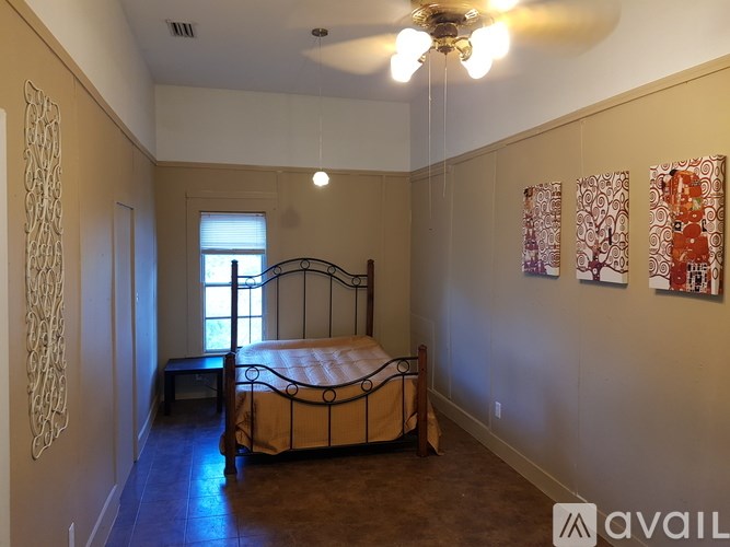 A bedroom with a bed, a window, and a ceiling fan.