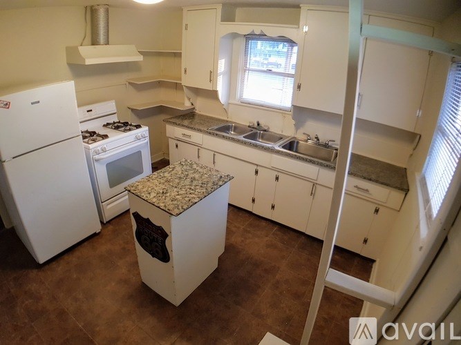 A kitchen with white appliances and cabinets.
