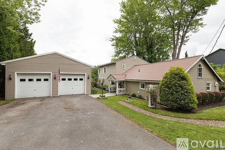 A house with a garage and a driveway in front of it.