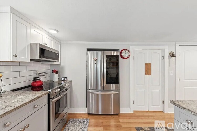 A kitchen with a refrigerator, stove, and microwave.