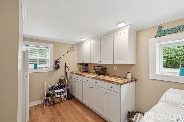 A kitchen with white cabinets and a wooden countertop.