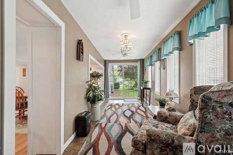 A living room with a rug, couch, and a ceiling fan.