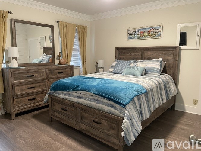 A bedroom with a bed, dresser, and mirror.
