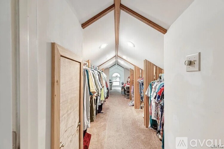 A row of clothes hanging on a rack in a room.