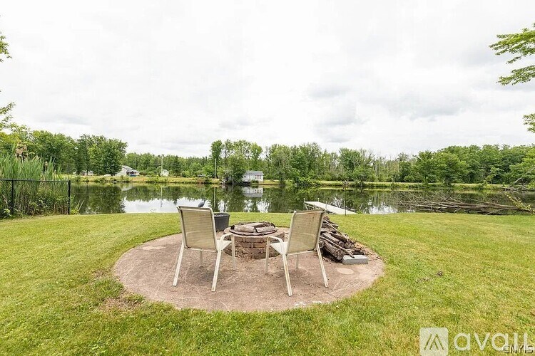 A backyard with a fire pit and chairs.