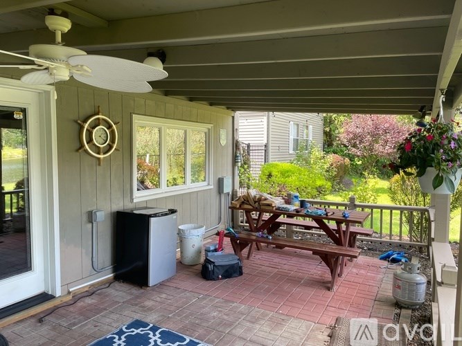 A patio with a table and chairs and a fan.