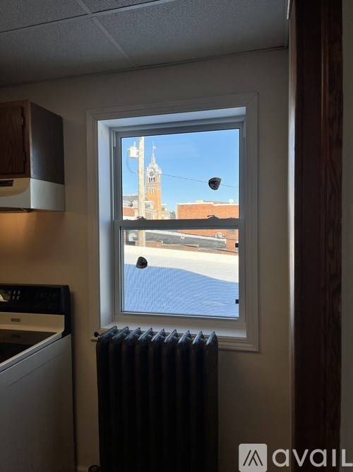 A window with a view of a building with a tower.