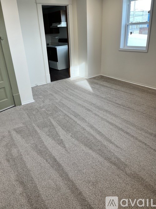 A room with a carpeted floor and a window.