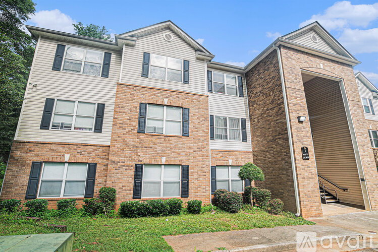 A two-story brick apartment building with a garage door on the side.