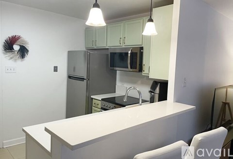 A kitchen with white cabinets and a white island.