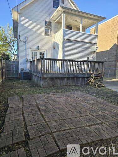 A white house with a brick patio in front.