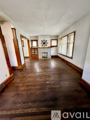 A living room with wood floors and a fireplace.