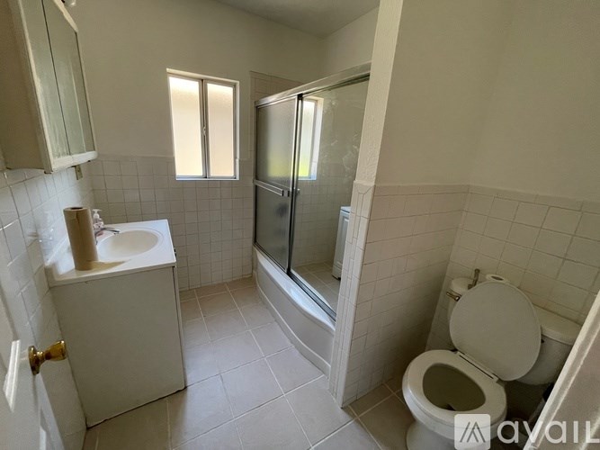 A bathroom with a toilet, sink, and shower.