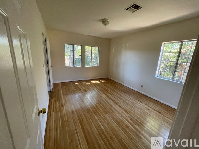 A room with wooden flooring and white walls.