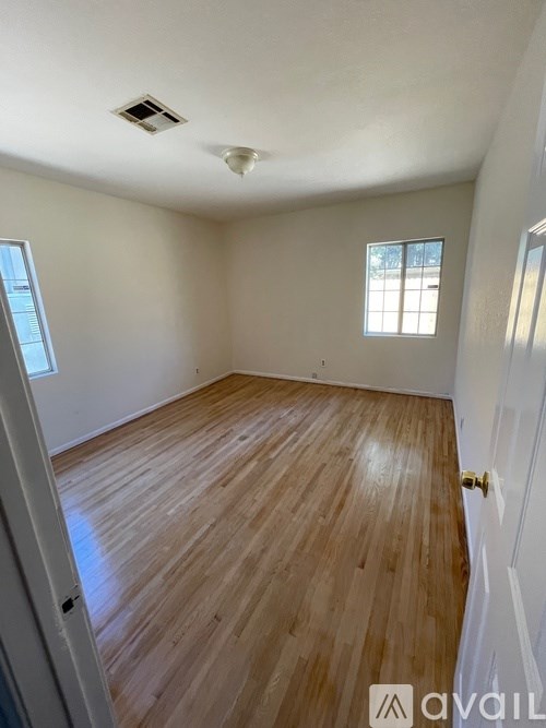 A room with wooden flooring and a window.
