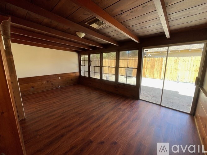 A room with wooden floors and a large window.