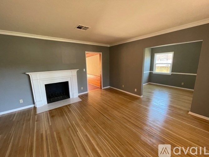 A room with a fireplace and wood flooring.
