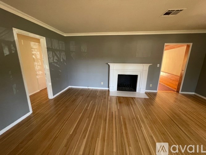 A room with a fireplace and wooden floors.