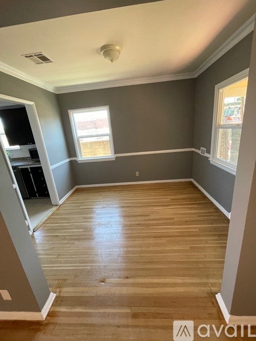 A room with wooden flooring and a window.