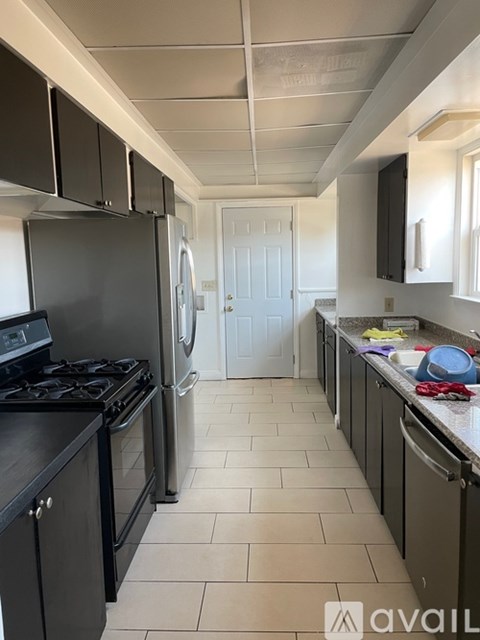 A kitchen with black cabinets and a white door in the background.