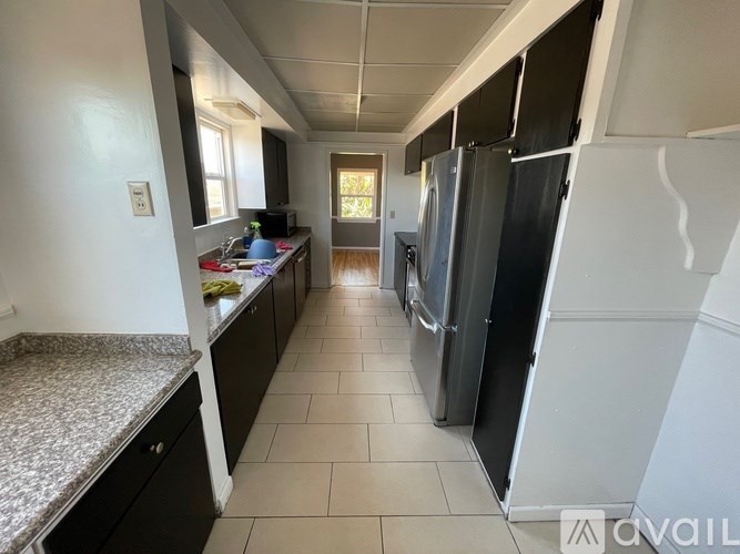 A kitchen with a refrigerator on the right side.