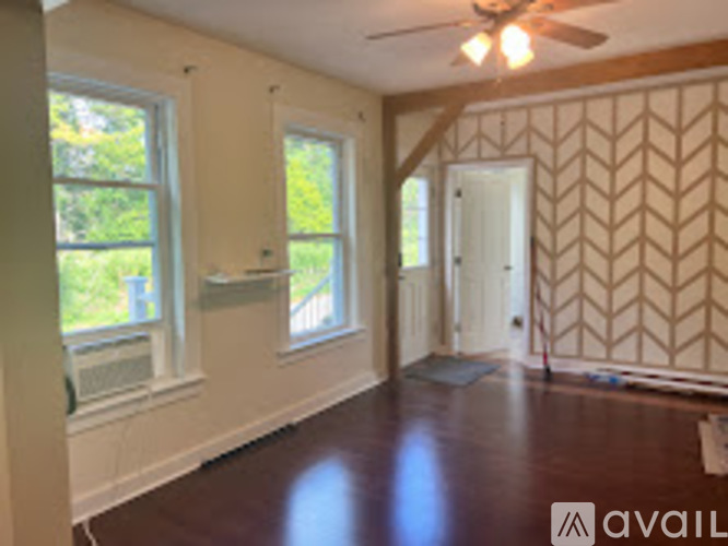 A room with a wooden floor and a wallpapered wall.