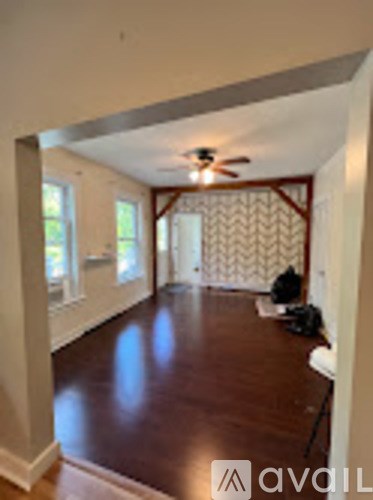 A room with a wooden floor and a ceiling fan.