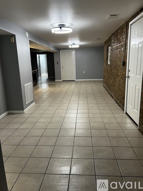 A spacious room with tiled flooring and a ceiling fan.