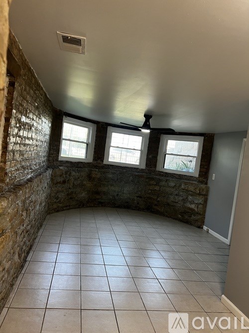 A room with a stone wall and tile flooring.