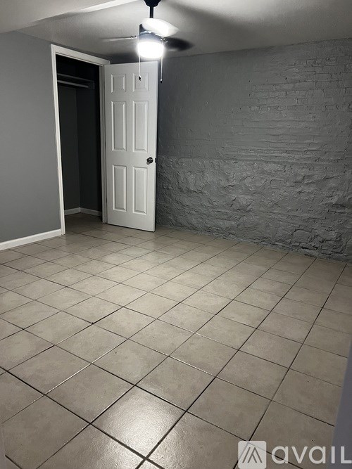 A room with a white door and tiled floor.