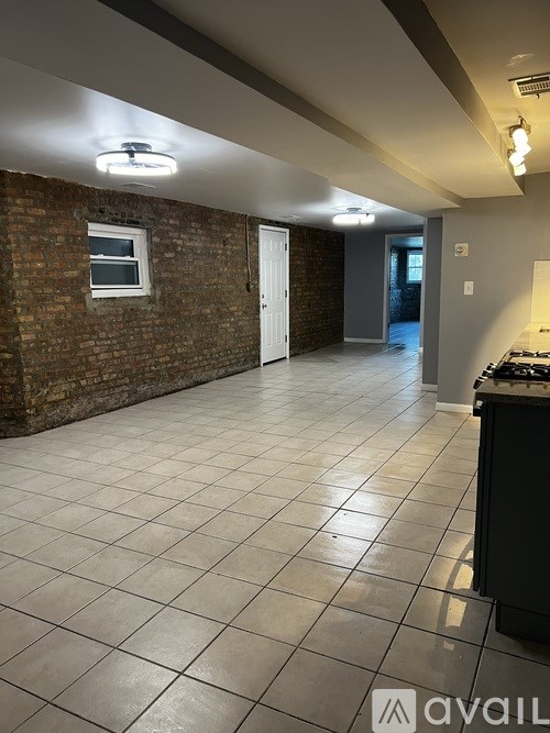 A room with a brick wall and tiled floor.