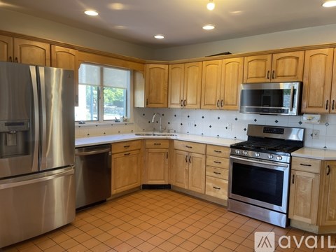 A kitchen with wooden cabinets and stainless steel appliances.