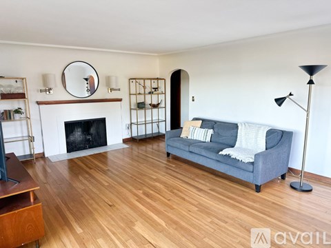 A living room with a grey couch and a fireplace.