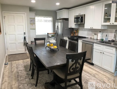 A kitchen with a table and chairs in the middle of the room.