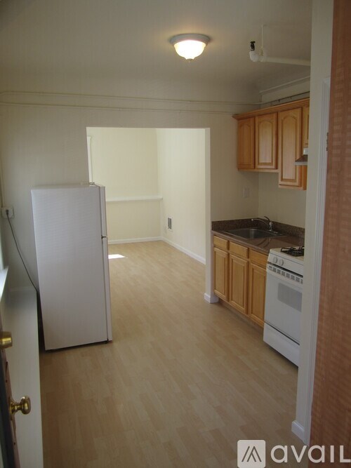 A kitchen with a white refrigerator and wooden cabinets.