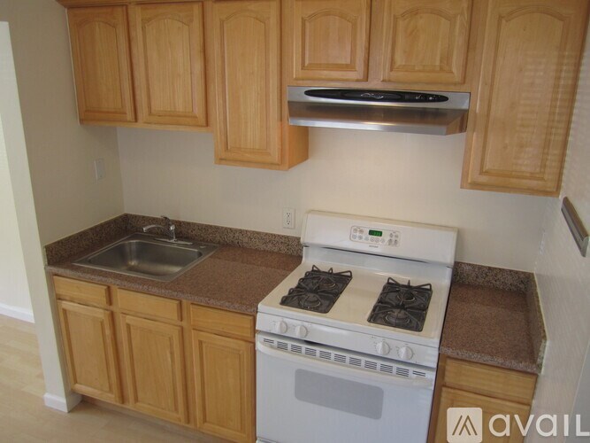 A kitchen with wooden cabinets and a white oven.