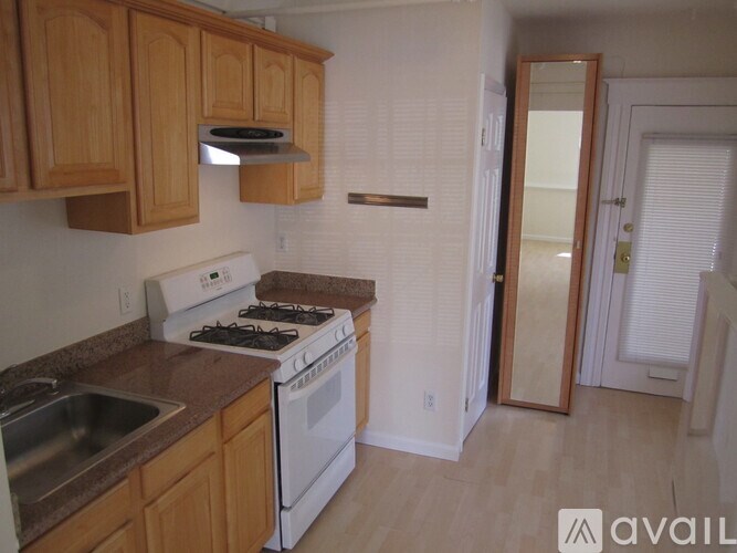 A kitchen with wooden cabinets and a white stove.