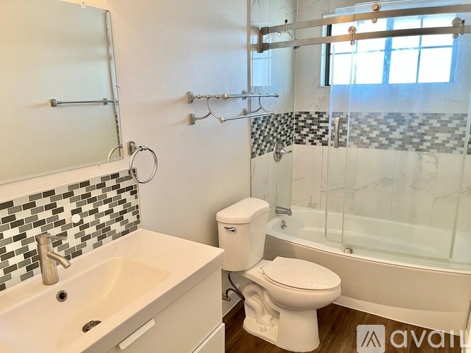 A white toilet sits next to a sink in a bathroom.